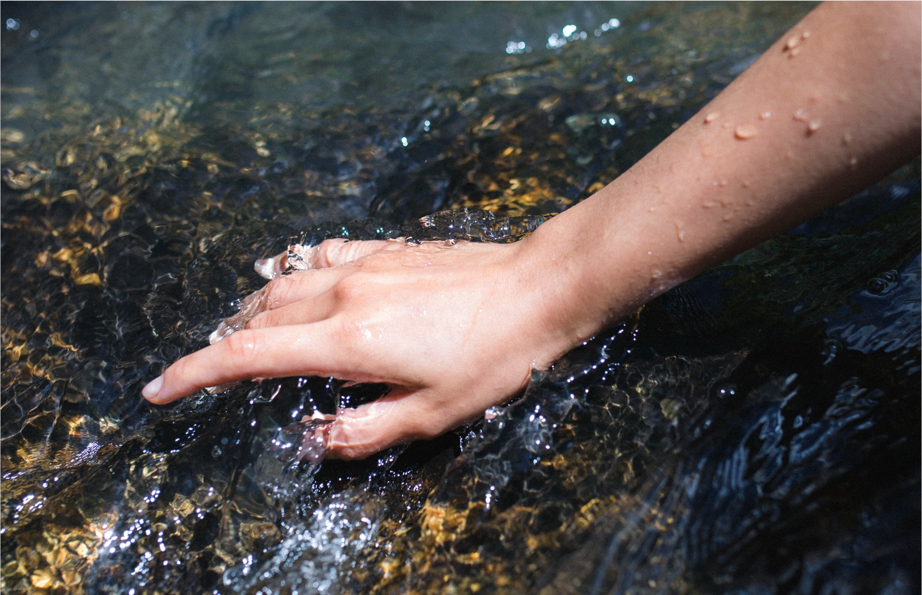 Haut und Wasser: Hand im fließenden Wasser